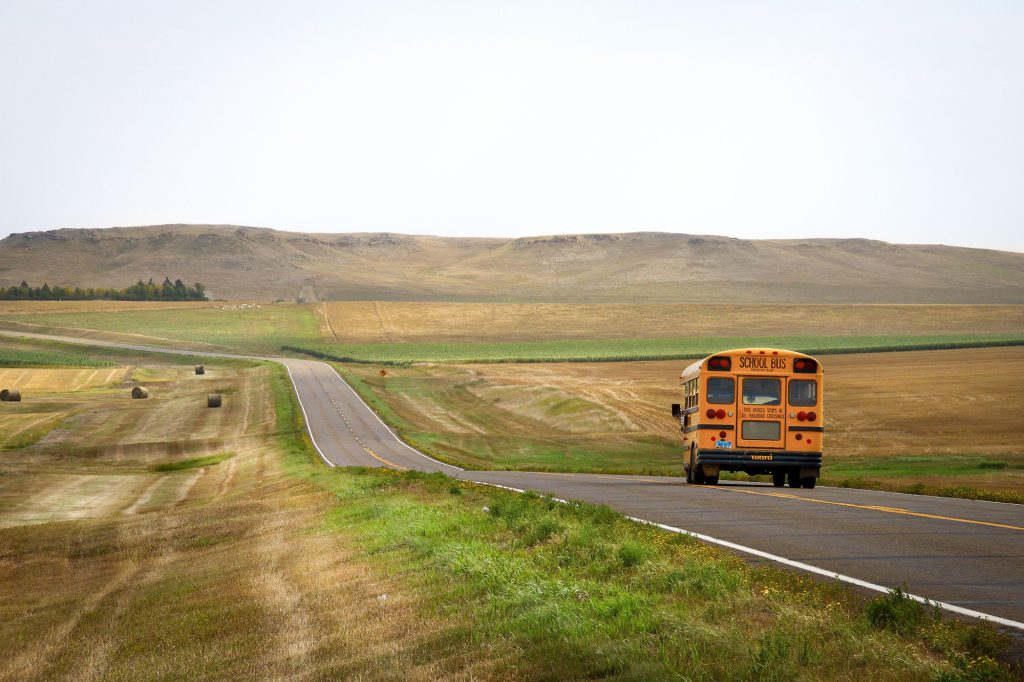 School bus driving on spacious country road